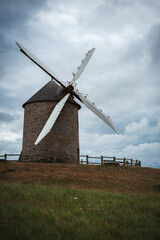 An ancient stone mill in an autumn field.