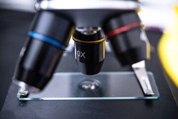 Close-Up of a Microscope Lens Focused on a Glass Slide in a Laboratory Setting for Scientific Research