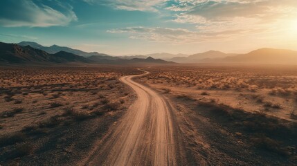 Naklejka premium A long, winding desert road cutting through the arid landscape, disappearing into the distance.