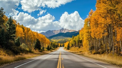 A scenic drive through the mountains with trees in full fall colors lining the road.