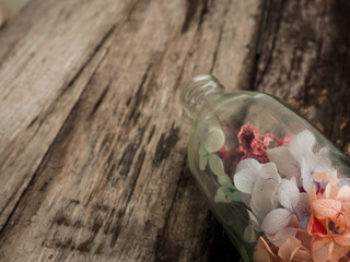 Dried flowers in glass bottle on old vintage wooden table for copy space