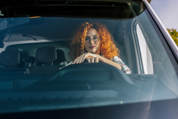 Portrait of a professional ginger woman driving a truck. People and industrial transportation...