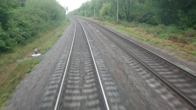 Railway. Video shooting from the locomotive window on behalf of the driver. A cloudy summer or autumn day.