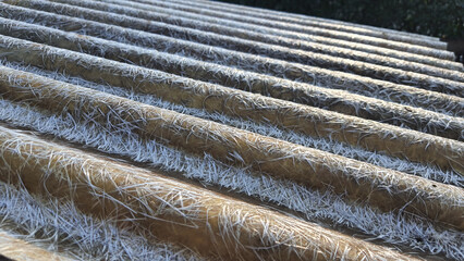 Old wavy brown roof with texture like white bird feather.