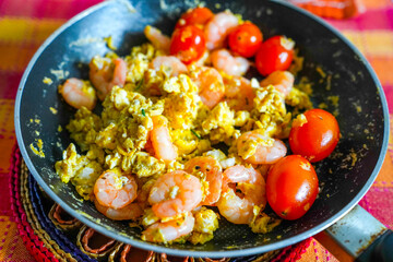 Scrambled eggs with tomato in a pan