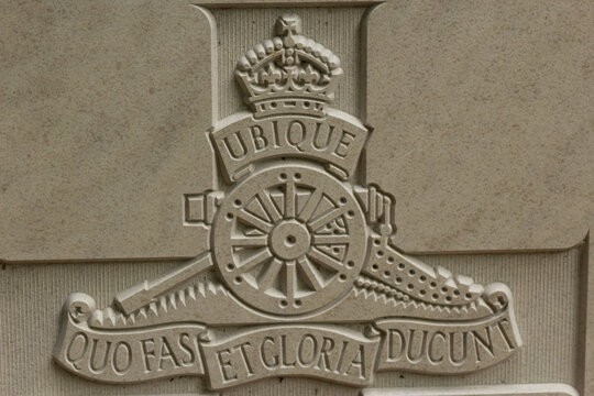 the badge of the British army's Royal Artillery Regiment on a Commonwealth War Graves headstone with the proud motto Everywhere where right and glory lead
