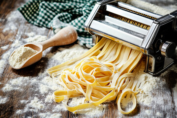An image of a pasta machine producing fresh tagliatelle.