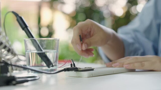 Close-up, Hand of woman installing analog dissolved oxygen sensor to microcontroller. Agriculture and aquaculture. Internet of Things (IoT).