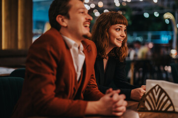 Two friends laughing and chatting in a warmly lit cafe. The atmosphere is relaxed and joyful, highlighting friendship and connection over a casual meeting.