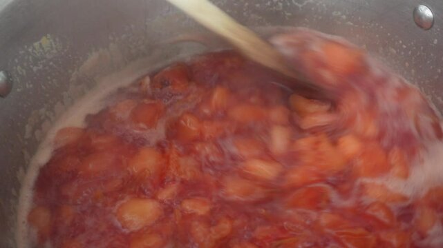 Making plum jam in a saucepan