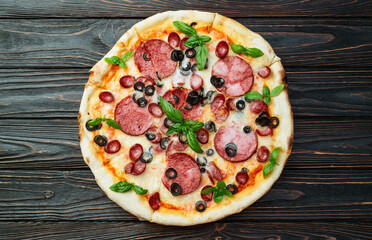 Pizza with mozzarella cheese , salami sausages , olives , and basil