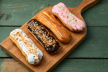 Assorted eclairs on a pastel top view Traditional French dessert
