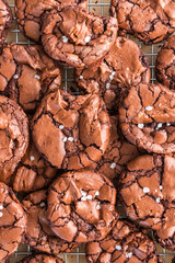 Brownie cookies cooling on a wire rack with flaky sea salt