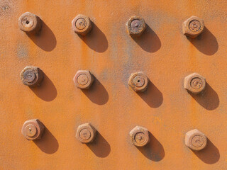 rusty nuts and bolts on a rusty steel plate