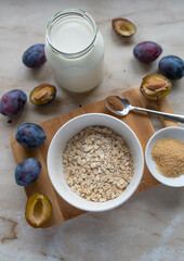 Ingredients for making a healthy oatmeal oder porridge with plums