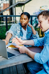 Professional male and female multiracial colleagues discussing cooperation on online business using...