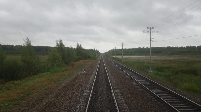 The slow movement of the train on the railway. Video shooting on behalf of the driver through the windshield of the locomotive. An autumn cloudy day.