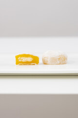 White mochi with yellow filling on white background
