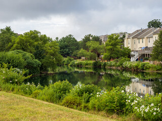 Obraz premium Tranquil Pond in Suburban Neighborhood with reflections from trees and houses in Ashburn, Virginia