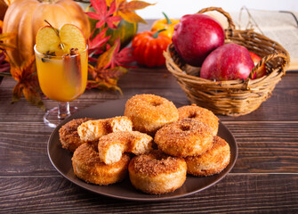 Sweet homemade apple cider donuts with cinnamon sugar on the wooden table. Autumn food.