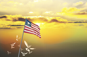 Liberia flag waving with flying doves against sunset or sunrise. Liberia flag for Republic Day and Independence Day.
