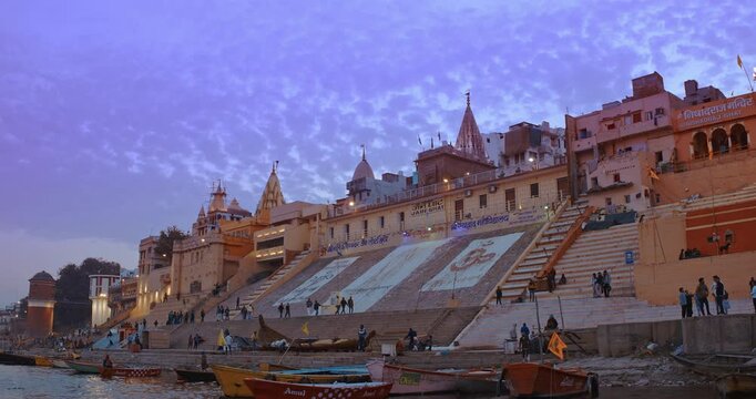 Varanasi, India. Close-up View On Jain Ghat. Purple Blue Sunset Sky At Evening Time. Site Of Jain Religion, Ghat Has Digambar Temple With Rising Dome. Evening At Sacred Varanasi Ghats. Tourists And