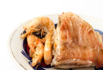Boiled shrimp and fish on a plate.