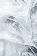 Obraz premium close-up of crumpled translucent plastic material spread out in folds. The white plastic appears light and thin, creating a textured, abstract pattern with soft shadows and highlights