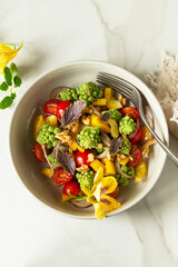 bowl of salad with romanesco cauliflower and cherry tomatoes on table, top view