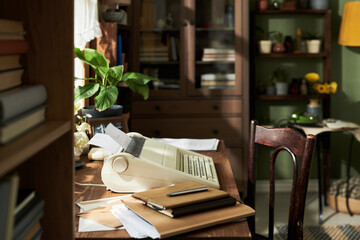 Vintage home office setup featuring an old typing machine, wooden desk, various houseplants, books,...