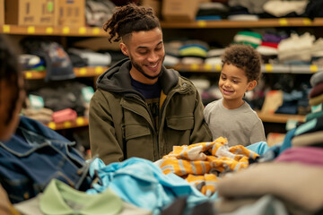 Father and Son Shopping for Clothes in a Thrift Store Filled with Colorful Garments