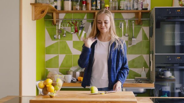 Household injury. Woman cut her finger with knife while she was chopping fruit at kitchen