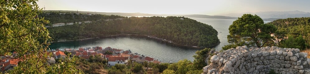 Evening panoramic landscape with shoreline buildings and harbor of city of Novigrad, Zadar district, northern Dalmatia, Croatia, during summer evening, viewed from Novigrad castle Fortica