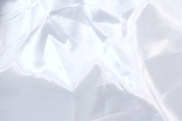 Silk fabric texture background of white. Close-up crumpled fabric texture. Luxury, elegant, bright and vivid, white cloth, and textile concepts. Texture background of white satin fabric.