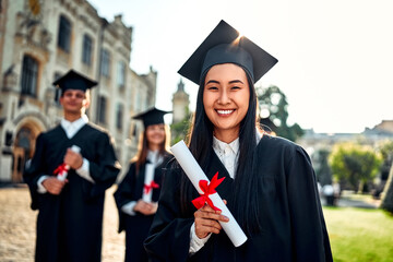 Graduation.Portrait happy smiling woman with diploma outdoors. Achievement, success,celebrate at college campus.