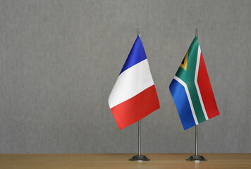 Table flags of France and South Africa on a gray blurred background