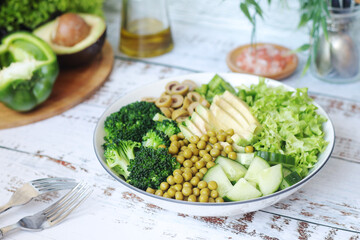 A bowl with a salad made of green vegetables