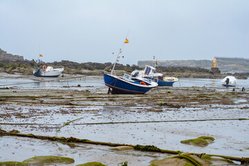 Fototapeta premium Boats on the sea floor at low tide near Santander, Cantabria, North Spain.