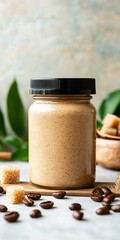 Aesthetic jar of creamy nut butter surrounded by coffee beans and sugar cubes on a rustic surface. Perfect for food photography.
