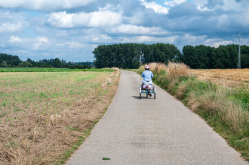 Obraz premium Portrait of a 41 yo woman with the Down Syndrome driving her tricycle in the fields, Hakendover, Tienen, Belgium