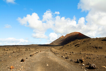 Road through the lava field and volcanos on hiking Termesana route (Ruta de Termesana) in Timanfaya national park, Lanzarote, Canary Islands , Spain
