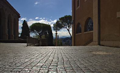 Sampietrini, the cobblestones typical of ancient Rome. Paved driveway overlooking the roman forum, in the backlighting.