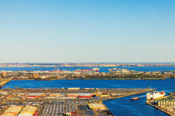 Aerial view from airplane window over industrial area of New York City with Hudson River and various structures. USA.