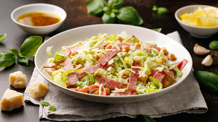 La Scala Salad with romaine lettuce, salami, mozzarella cheese and chickpeas in white plate.