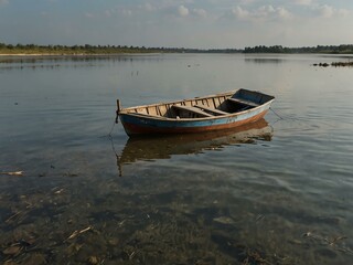 Small boat drifting on polluted shallow water.
