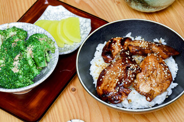 Teriyaki chicken is a Japanese dish of chicken glazed with a sweet and savory soy-based sauce, grilled to perfection for a flavorful, caramelized meat. Served with rice, seaweed salad and pickels.