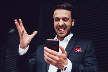 Angry man reading received news with text message while testing new banking application for making online money transfer, stressful male boss broker formally dressed checking business website