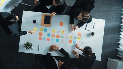 Top view of professional business team planning marketing strategy. Group of diverse business people writing and sharing creative idea. Smart project manager walking and standing at table. Directorate
