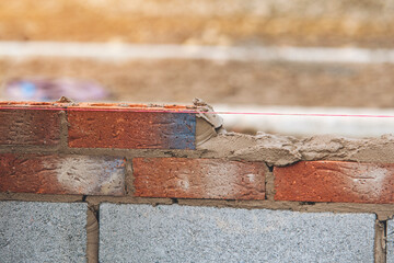 Bricklayers Build Sturdy Wall in  Warm Afternoon Sun at  Construction Site