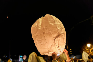 Person holding sky lantern during night celebration
